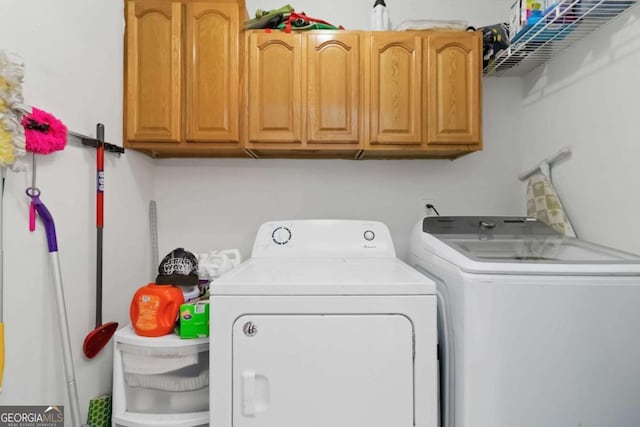 laundry room featuring cabinets and washing machine and clothes dryer