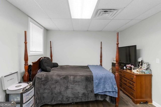 bedroom with hardwood / wood-style floors and a drop ceiling