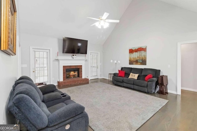 living room with ceiling fan, dark wood-type flooring, a fireplace, and high vaulted ceiling