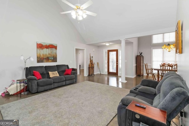 living room with ornate columns, ceiling fan, and high vaulted ceiling