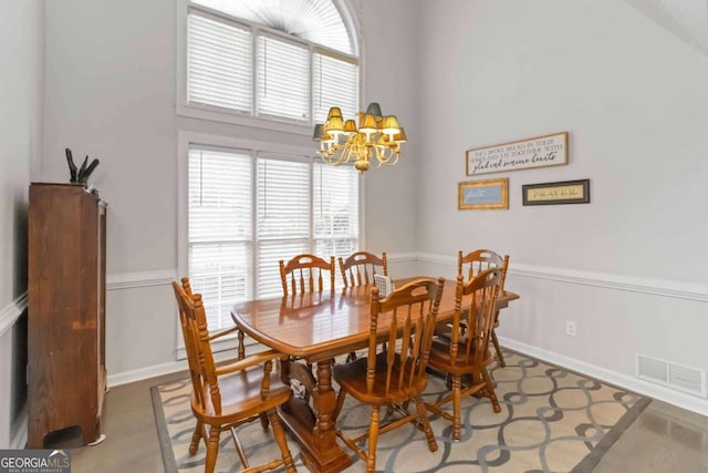 dining room with a chandelier and a high ceiling