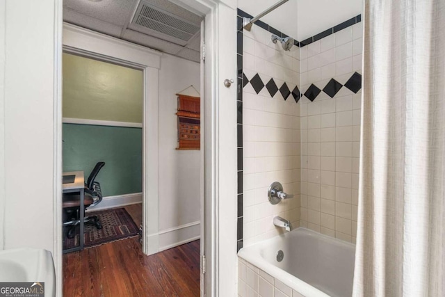 bathroom with shower / tub combo with curtain and wood-type flooring