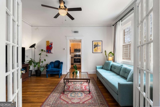 living room featuring ceiling fan, dark wood-type flooring, and ornamental molding