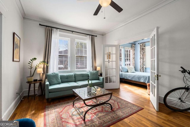 living room with hardwood / wood-style floors, ceiling fan, french doors, and crown molding