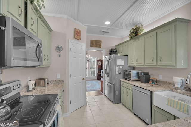 kitchen featuring green cabinets, appliances with stainless steel finishes, ornamental molding, a sink, and light stone countertops