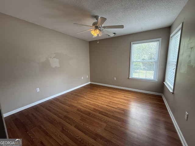 spare room featuring ceiling fan, wood finished floors, a textured ceiling, and baseboards