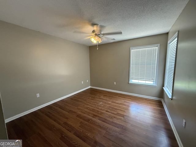unfurnished room featuring ceiling fan, baseboards, dark wood-style flooring, and a textured ceiling