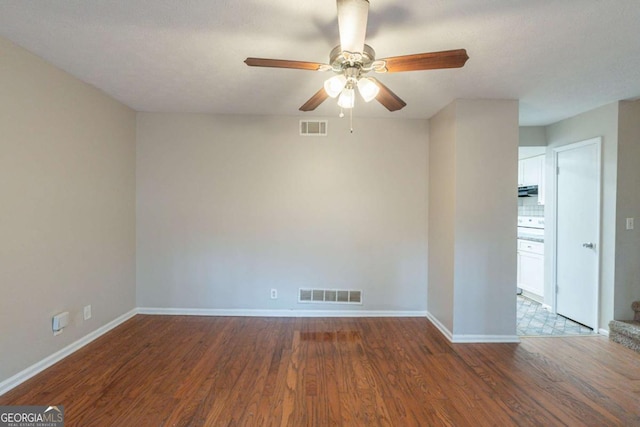 empty room with ceiling fan and dark hardwood / wood-style floors