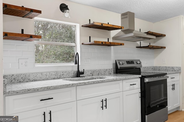 kitchen featuring ventilation hood, sink, white cabinets, stainless steel range with electric stovetop, and light stone counters