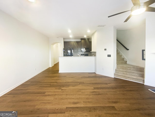 unfurnished living room with dark hardwood / wood-style floors and ceiling fan