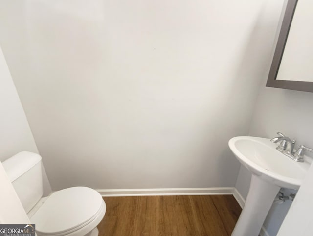 bathroom featuring wood-type flooring, toilet, and sink