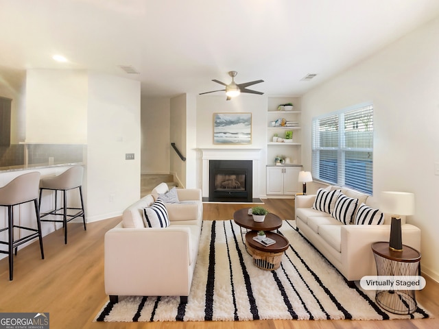 living room with ceiling fan and light hardwood / wood-style flooring