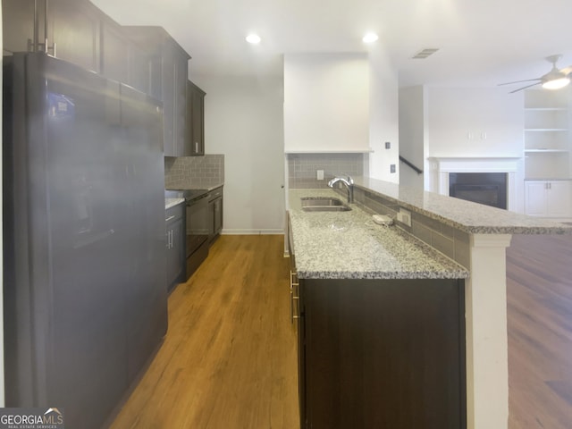 kitchen featuring decorative backsplash, stainless steel refrigerator, black / electric stove, sink, and kitchen peninsula