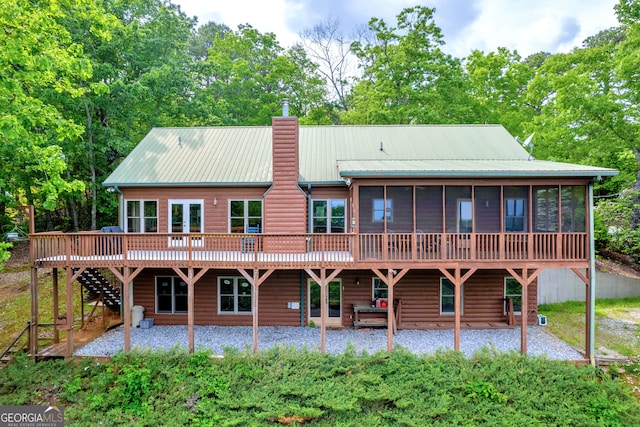 rear view of property with a sunroom and a deck