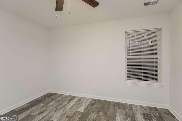 spare room with dark wood-type flooring and ceiling fan