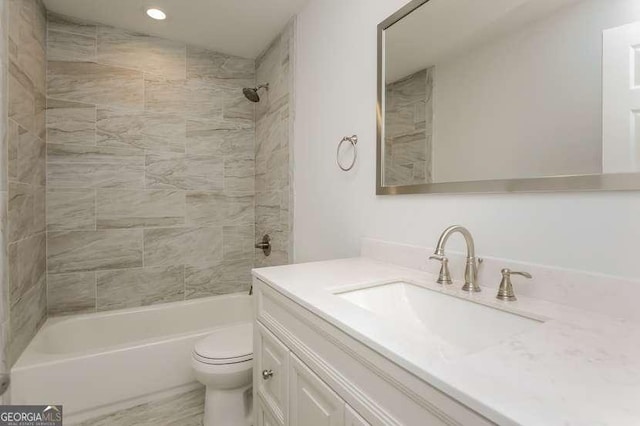 full bathroom with vanity, tiled shower / bath combo, and toilet