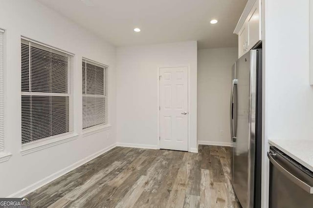 interior space with appliances with stainless steel finishes, dark wood-type flooring, and white cabinets