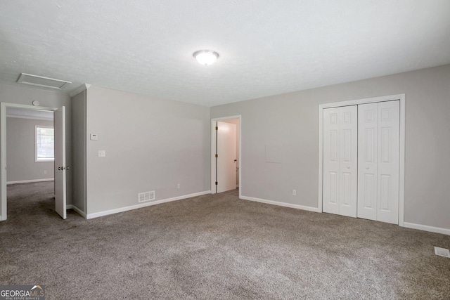 unfurnished bedroom with carpet flooring, a textured ceiling, and a closet