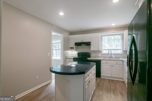 kitchen featuring sink, white cabinetry, a kitchen island, hardwood / wood-style floors, and black appliances