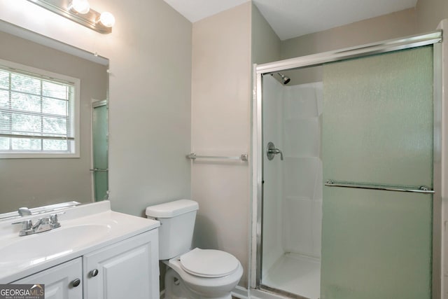 bathroom with vanity, toilet, and a shower with shower door
