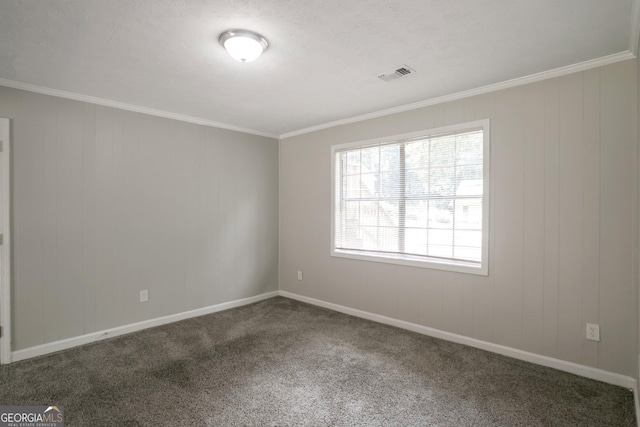 empty room featuring crown molding and dark carpet