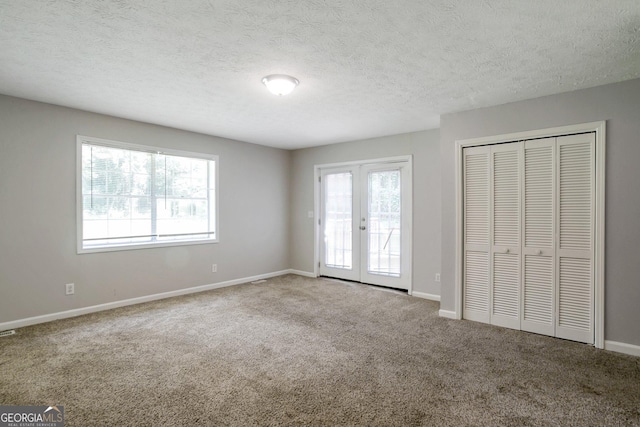 unfurnished bedroom with multiple windows, access to outside, french doors, and carpet