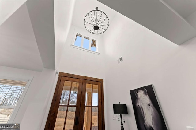 foyer with a towering ceiling and french doors