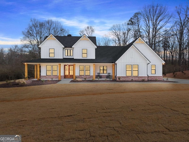 modern farmhouse with a front yard and a porch