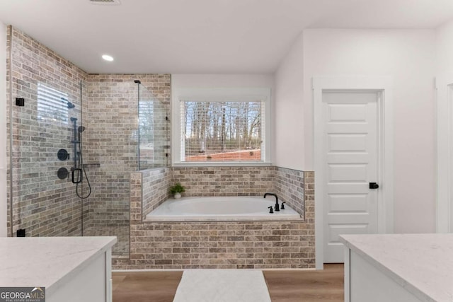 bathroom with vanity, hardwood / wood-style flooring, and shower with separate bathtub