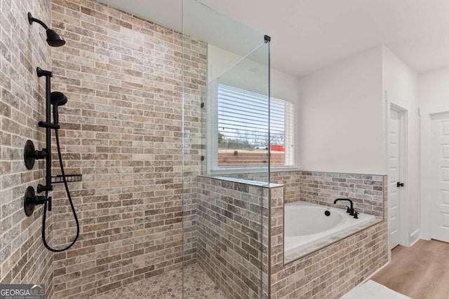 bathroom with hardwood / wood-style flooring and independent shower and bath