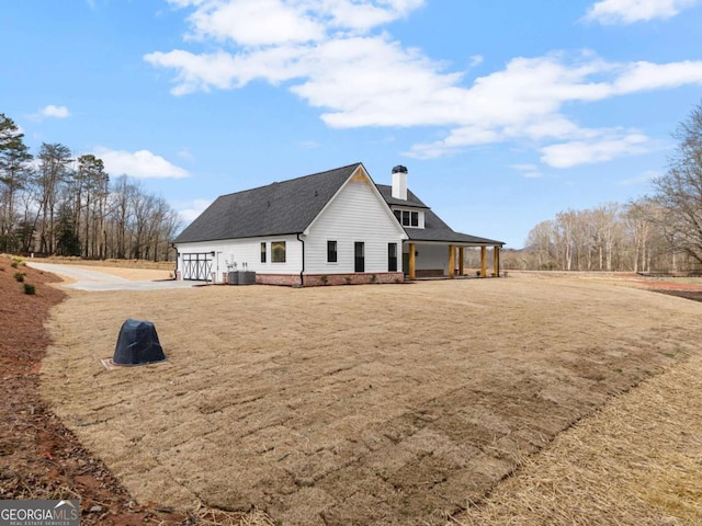 rear view of property with central AC and a lawn