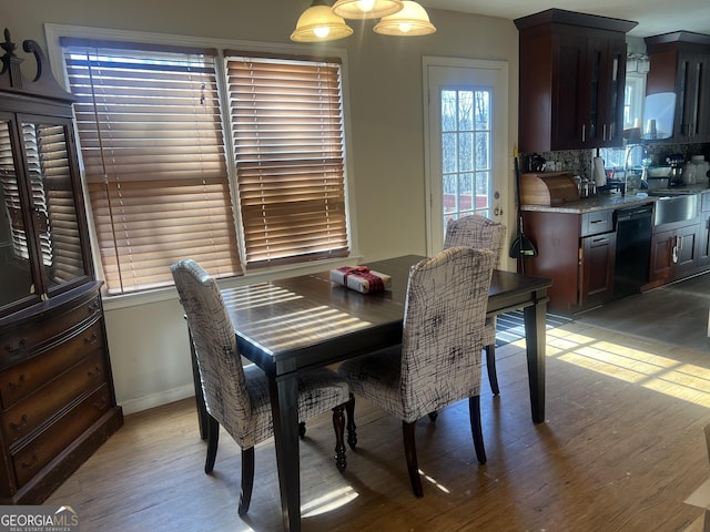 dining area with light wood-type flooring and baseboards