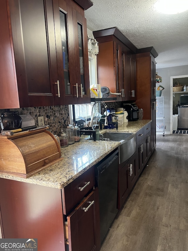 kitchen with black dishwasher, a textured ceiling, dark wood finished floors, and light stone countertops