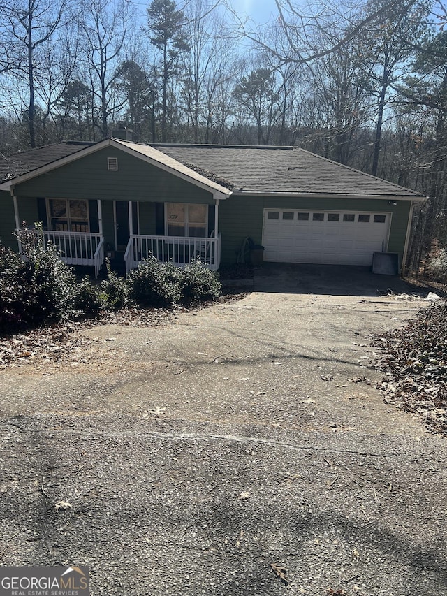 view of front of house featuring a porch, cooling unit, driveway, and a garage