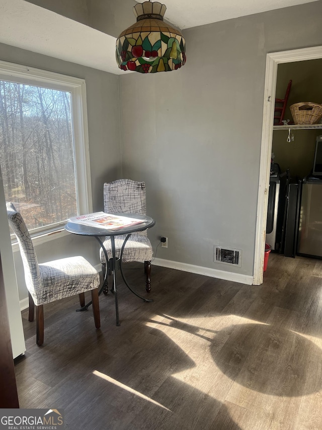 dining room featuring visible vents, baseboards, and wood finished floors