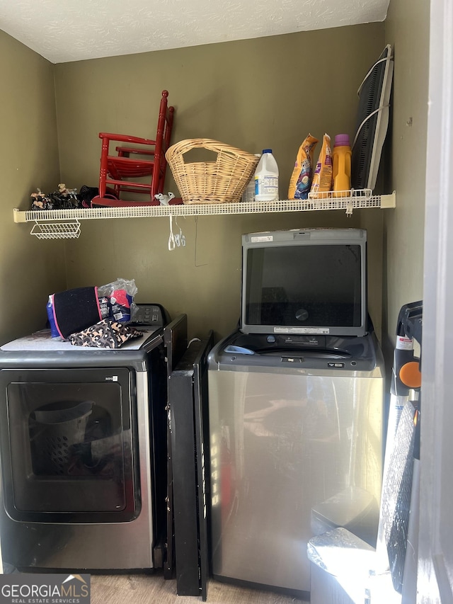 laundry room with laundry area, a textured ceiling, and independent washer and dryer