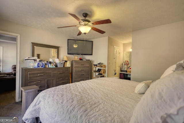 carpeted bedroom featuring a textured ceiling and ceiling fan