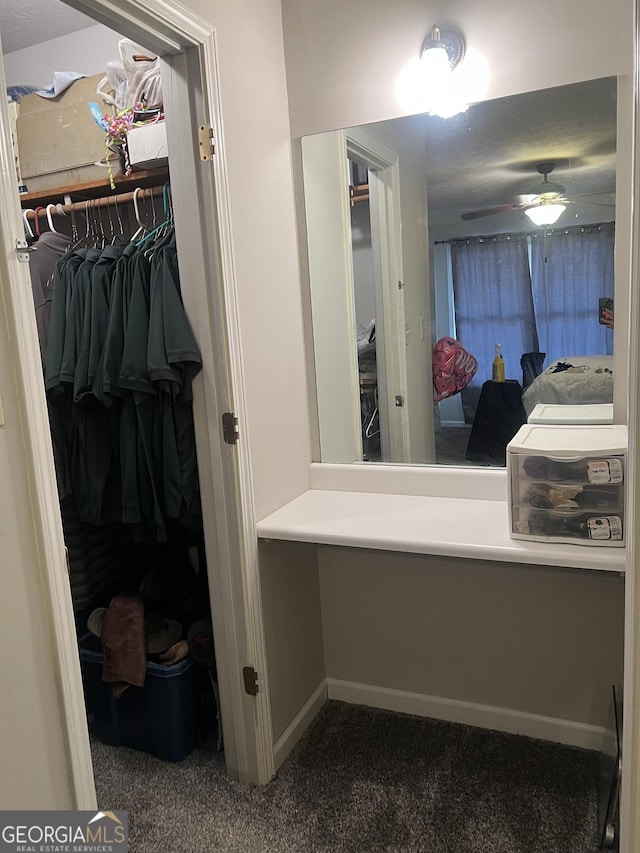 bathroom with ceiling fan, baseboards, and a walk in closet