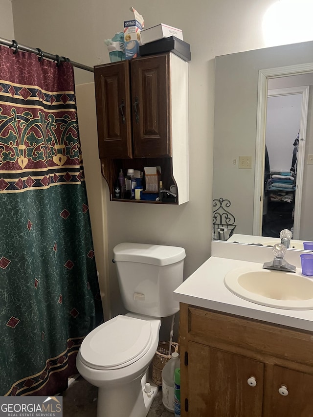 bathroom featuring toilet, a shower with shower curtain, and vanity