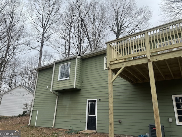 back of property with cooling unit and a wooden deck