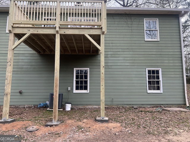 rear view of house with central AC unit and a wooden deck