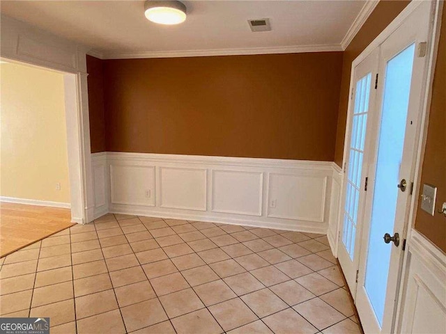 empty room featuring ornamental molding and light tile patterned flooring