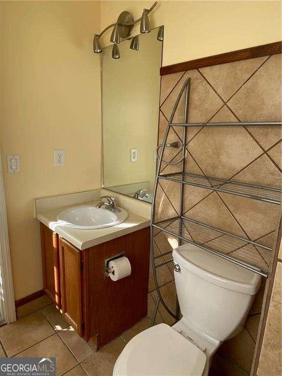 bathroom featuring tile patterned flooring, vanity, and toilet