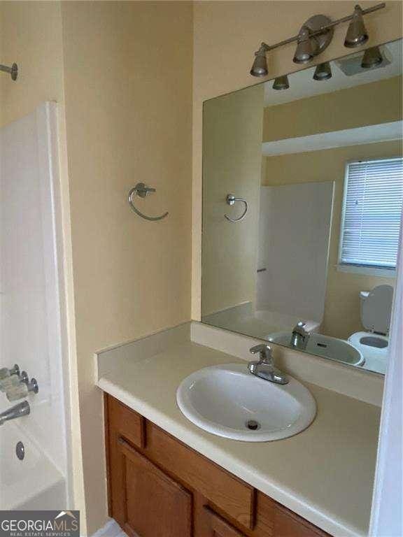 full bathroom with vanity,  shower combination, and toilet