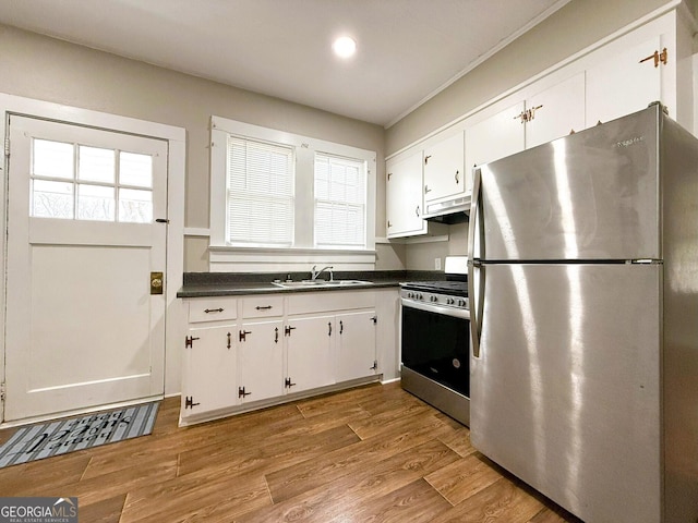 kitchen featuring appliances with stainless steel finishes, white cabinets, and light hardwood / wood-style flooring