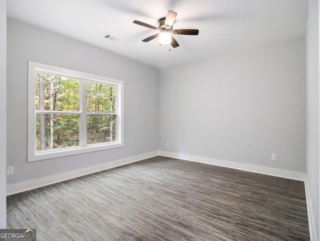 spare room with dark hardwood / wood-style flooring and ceiling fan