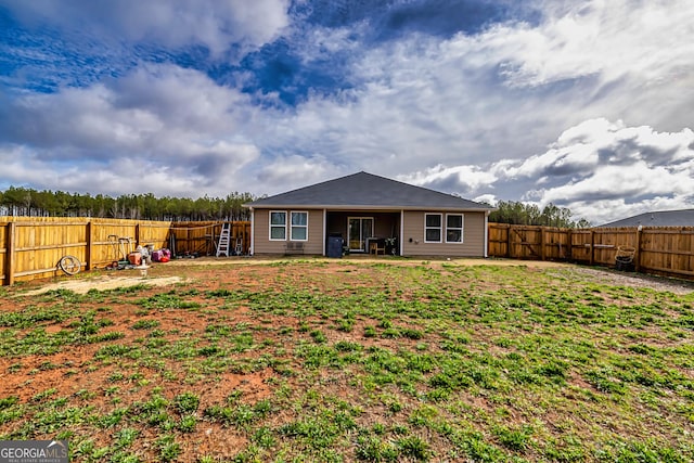 rear view of house featuring a yard and a patio area