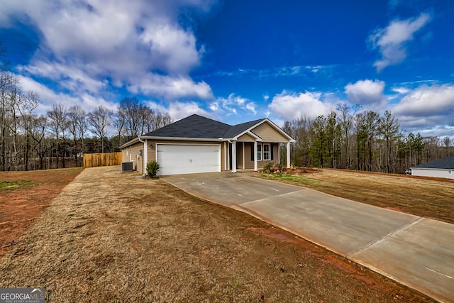 view of front of house featuring a garage, a front yard, and central air condition unit