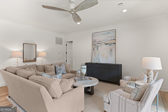 living room with crown molding, ceiling fan, and light hardwood / wood-style flooring