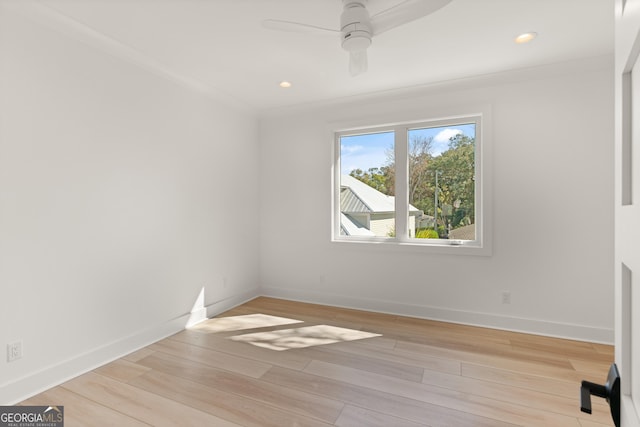 empty room with ceiling fan, ornamental molding, and light hardwood / wood-style flooring